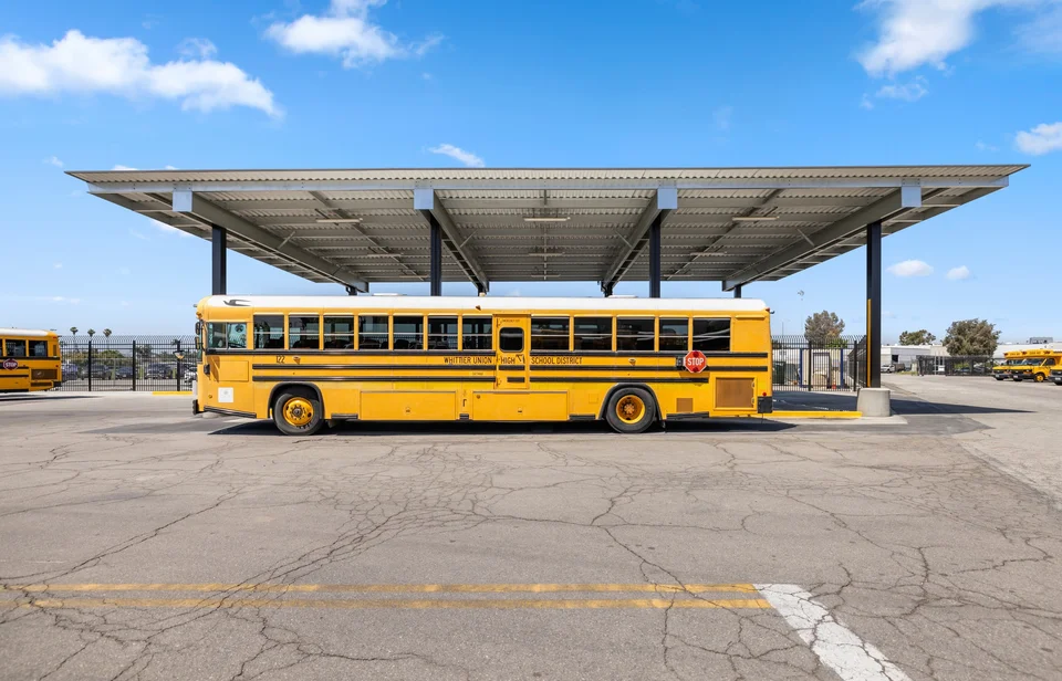 Tall steel canopy providing covered parking for school buses